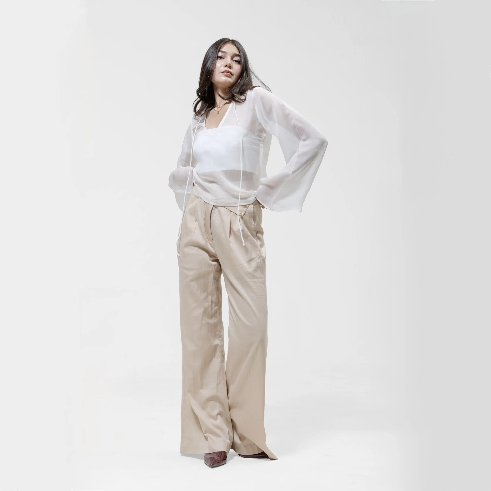 QISSEY BEIGE WIDE-LEG PANTS — HIGH-WAISTED TROUSERS IN A WARM BEIGE FEATURING A DISTINCTIVE CROSSOVER WAISTBAND PANEL. FALLS SMOOT